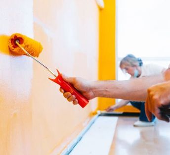 pintores pintando pared de amarillo